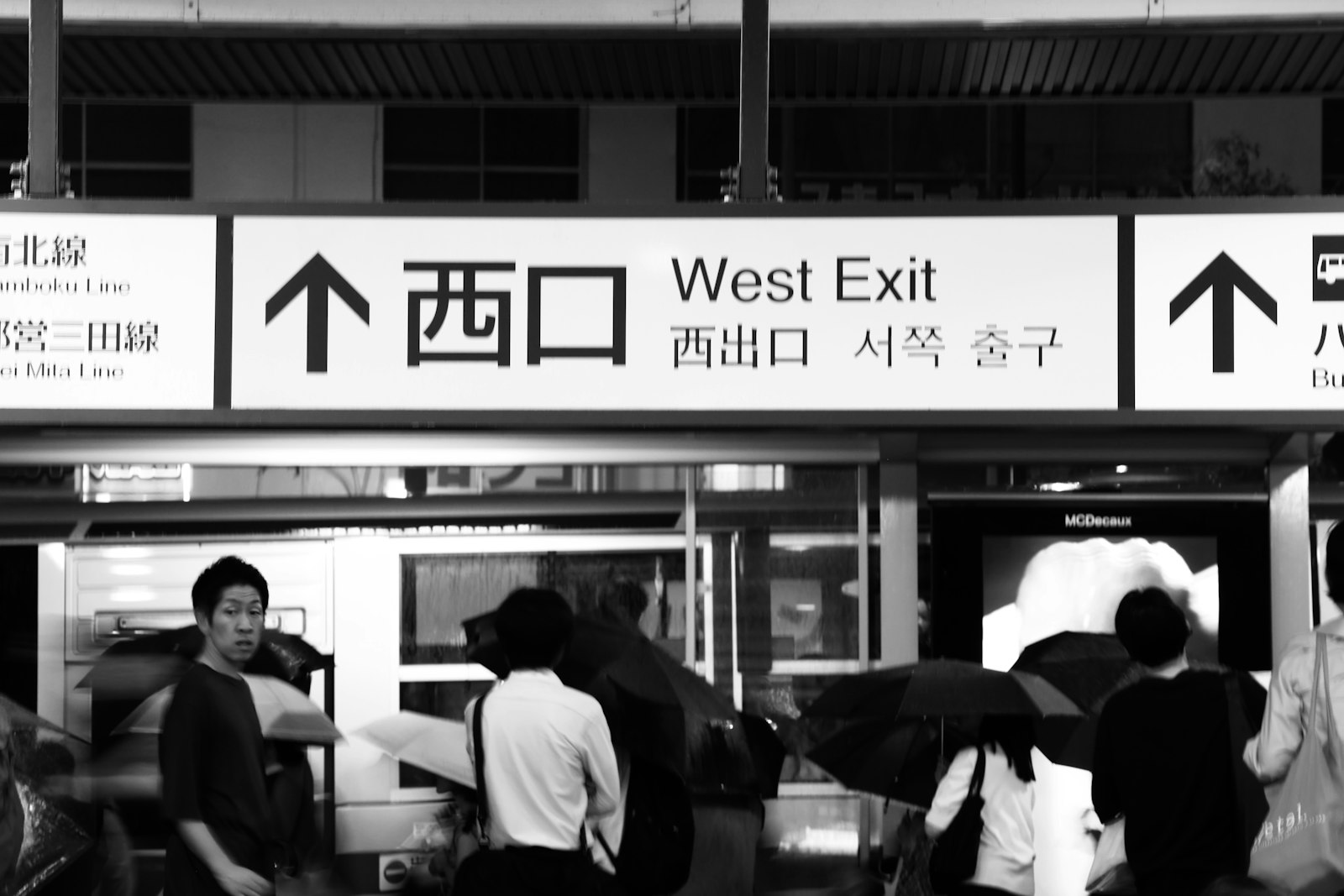 Exit sign at Shibuya station showing south exit kanji and arrow