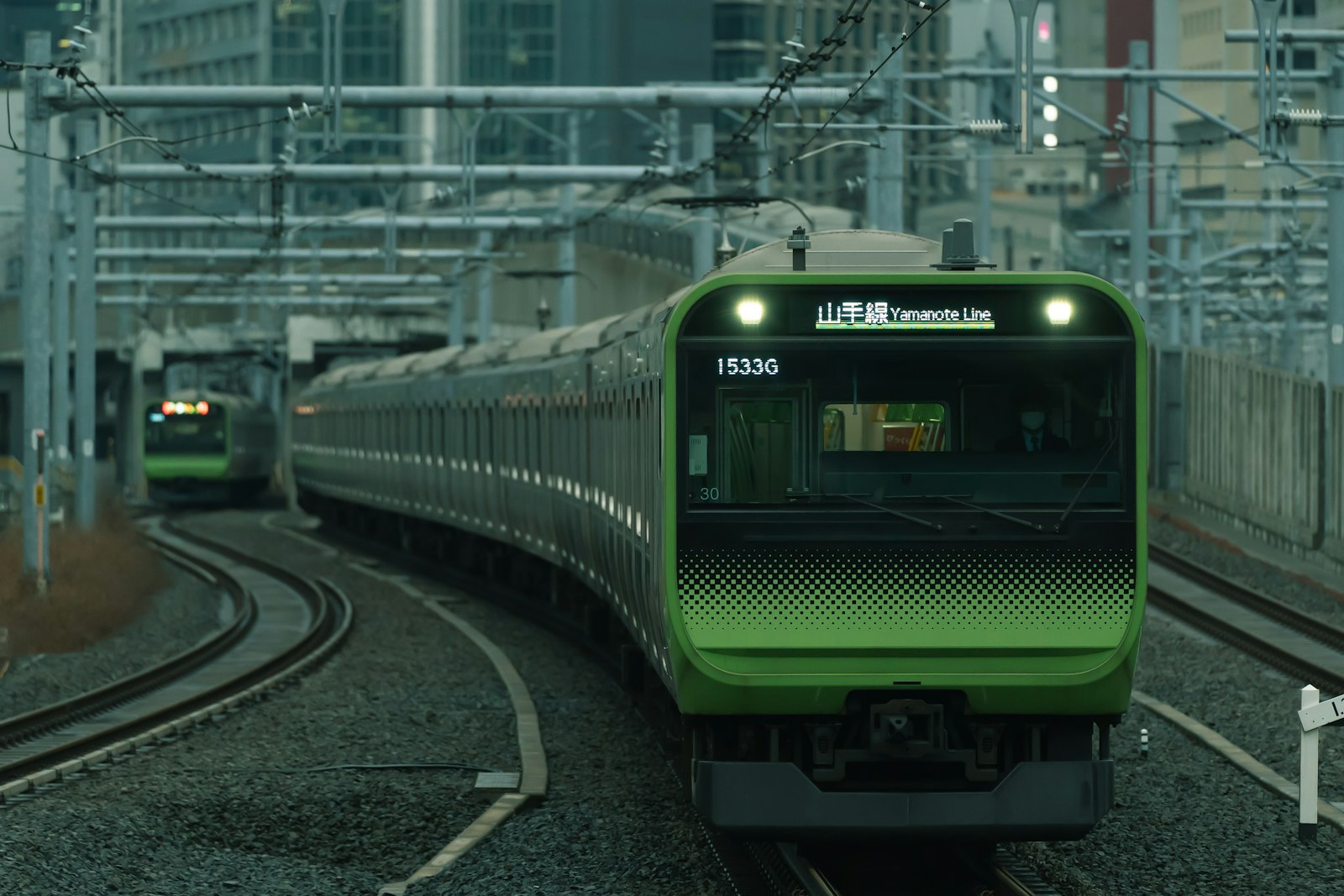 Yamanote line train arriving at Shinjuku station with platform signs visible
